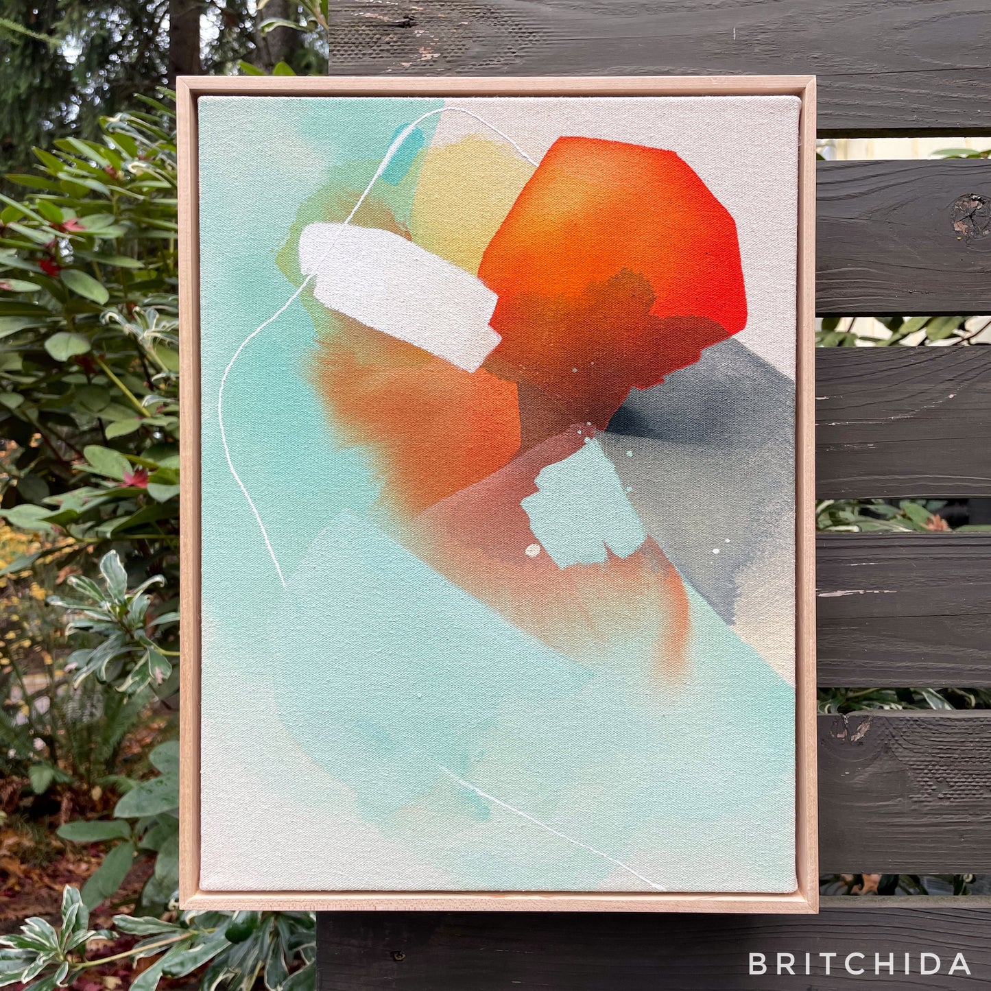framed print of abstract painting with orange, teal, yellow, black, and white shapes