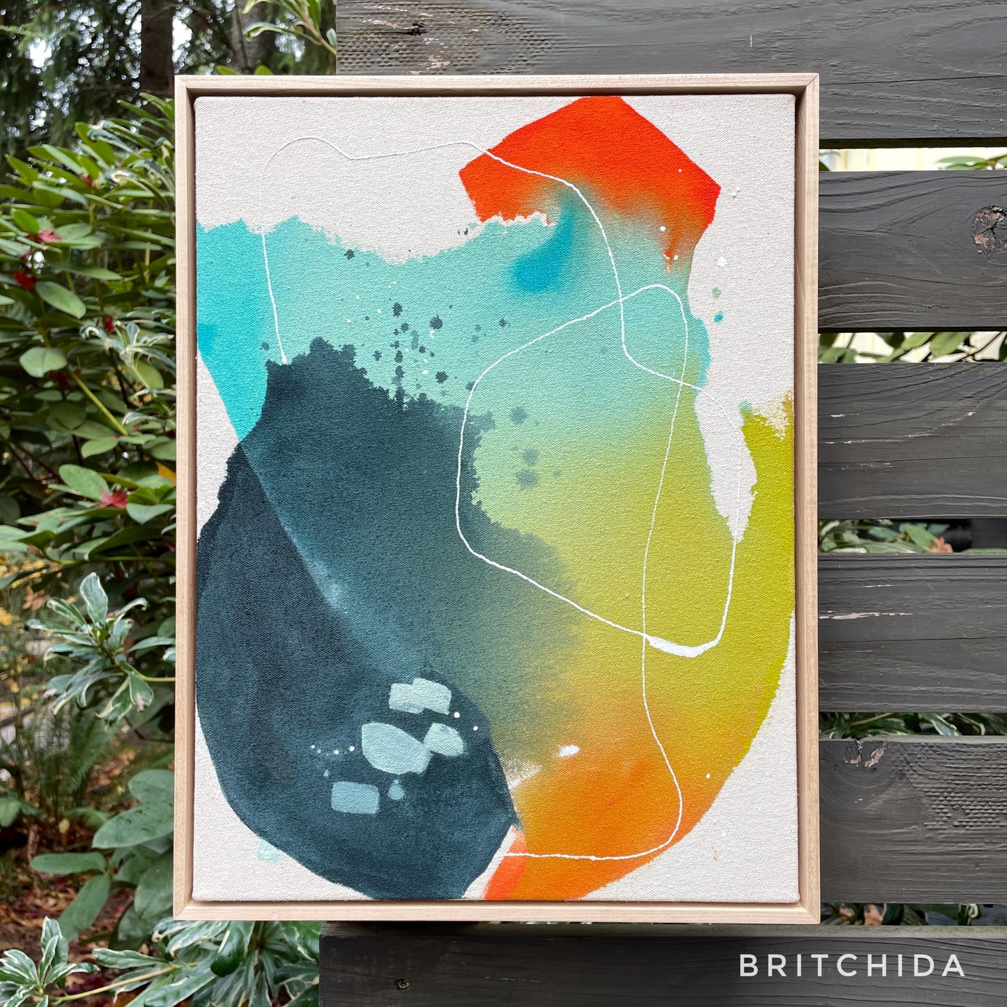 large framed print of abstract painting with navy, teal, orange, red, yellow, and lime green shapes. thin white lines throughout