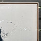 close up photo of original painting by britchida showing tan canvas with navy paint specks and wooden frame