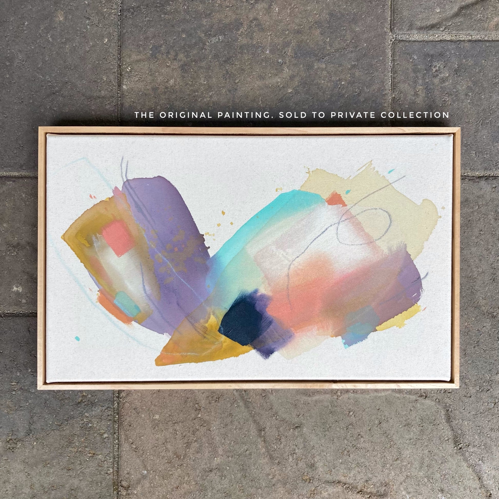 framed abstract painting by britchida with yellow, teal, peach, navy, and lilac shapes with various thin lines resting on stone floor and the text: "THE ORIGINAL PAINTING: SOLD TO PRIVATE COLLECTION"