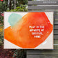 framed original large abstract painting by britchida. large orange shape with light teal shape with white paint specks and looping thin white line. the white block text reads "PLAY IS THE OPPOSITE OF SURVIVAL MODE"