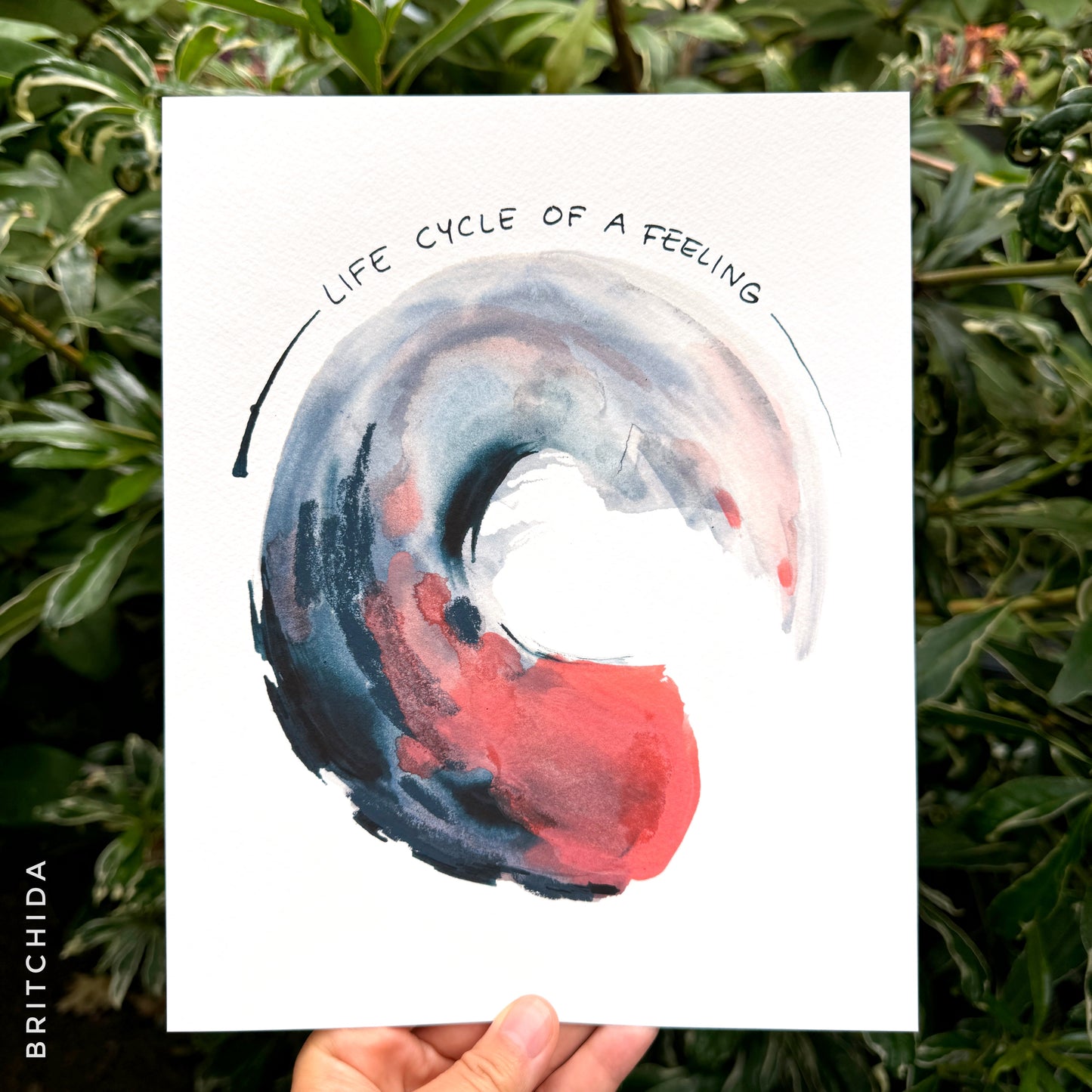 the words “life cycle of a feeling” wrap around a large circular stroke of gray and pink paint that is bold at its start and fade toward the end