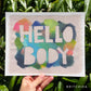 print of rough edged raw canvas with bright multicolor marks on it with the words “HELLO BODY” masked out.