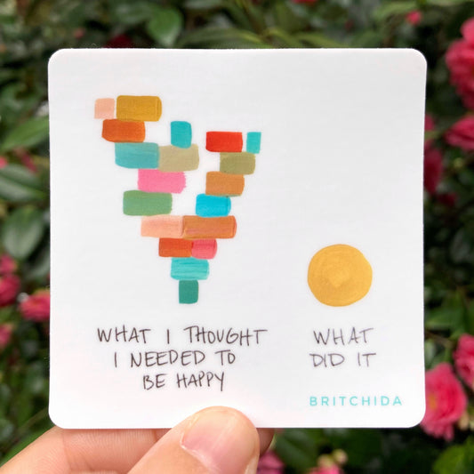 3" sticker of What Did It print with stacked rectangles in various colors with the text "what I thought I needed to be happy" on the left. On the right is a yellow circle with the text "what did it"