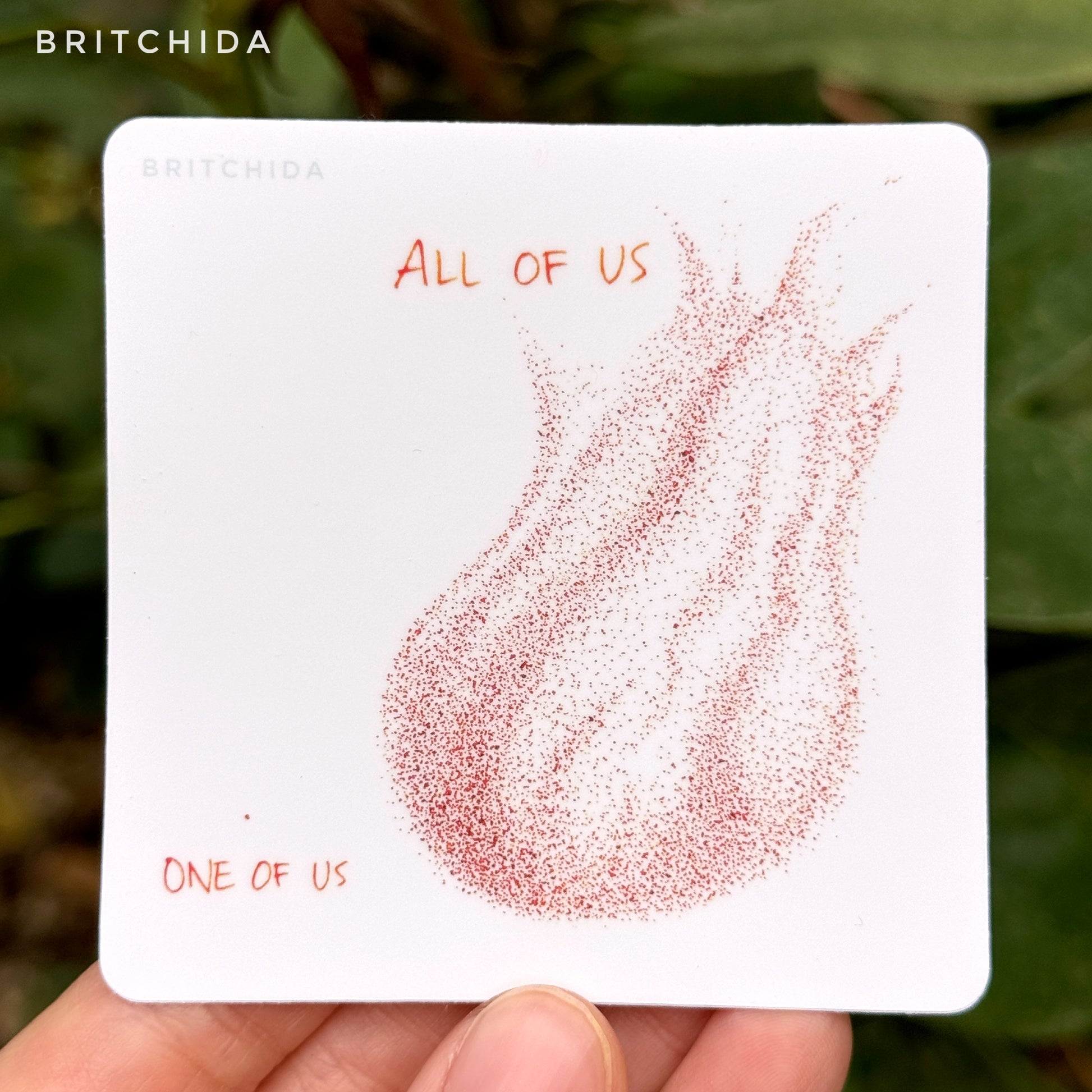 sticker of All of Us print with a single orange dot in the lower left corner and the label "one of us". On the right is a larger shape of several orange dots with the label "all of us"