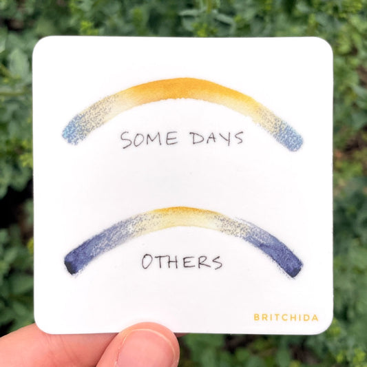 sticker of Solstice print with 2 arches of blue to yellow and back to blue gradient. The top arch, labeled "some days" has a large yellow section in the middle. The bottom arch labeled "others" has a smaller yellow section in the middle