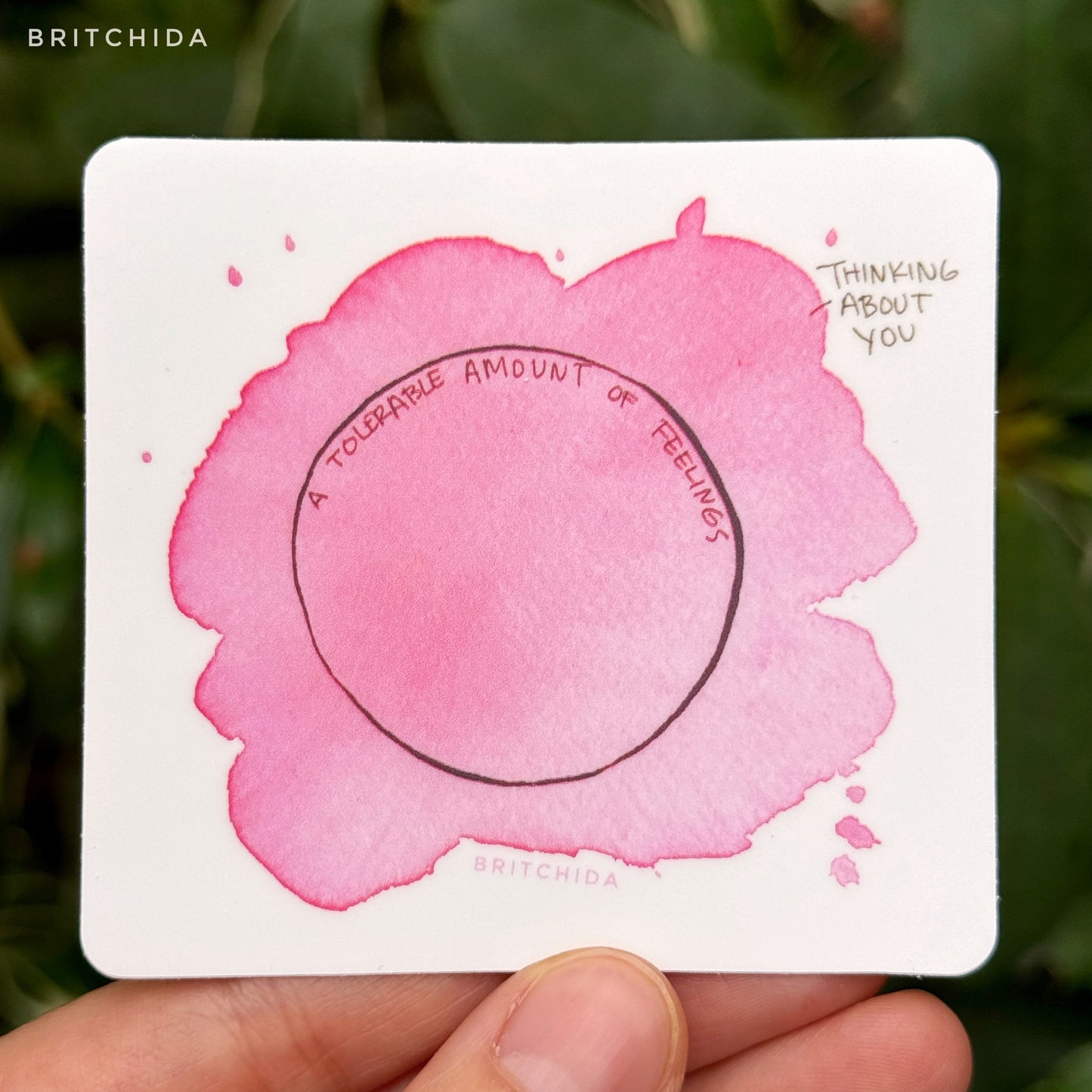 sticker of Thinking About You print with a circle in the center labeled "a tolerable amount of feelings" and a large pink watercolor spot that covers and extends from the circle labeled "thinking about you"