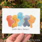 five abstract shapes in a slight arc that fit together perfectly, in an earthy and muted rainbow. Titled: Chosen Family Portrait.