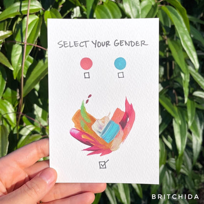 a pink circle next to a blue circle both with check marks under them. Larger, dynamic, varied colors of paint are under the circles with a a checked check mark. The title "Select Your Gender" is on the top.